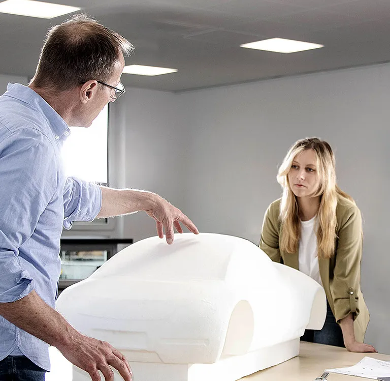 Ein PolyWorks® Trainer erklärt einer Kursteilnehmerin einer Expertenschulung das Rerverse Engineering anhand eines Autos