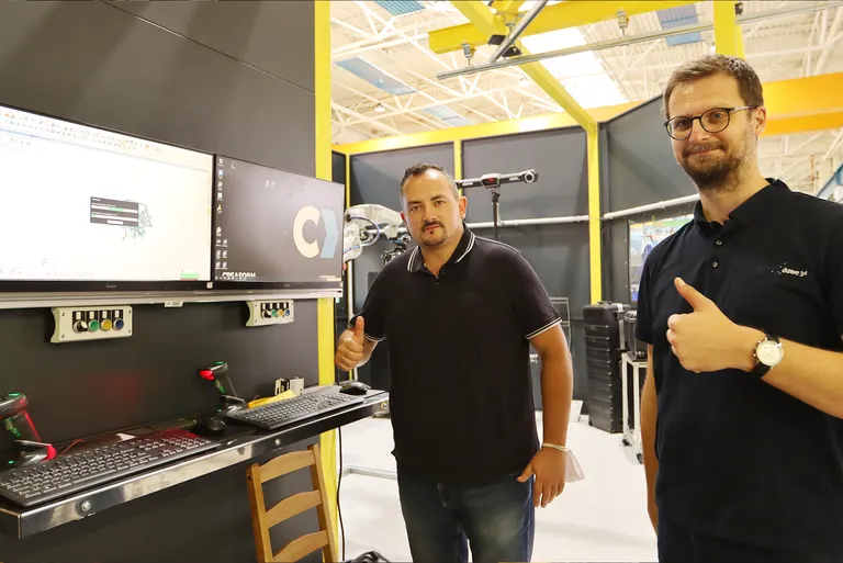 Tommy Laukdrej von WAT mit Thomas Neudert von Duwe-3d vor einer automatisierten Messzelle für die 3D-Vermessung