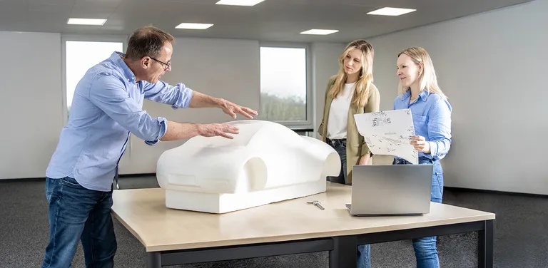 Messtechniker erklärt anhand eines Claymodells die Designphase eines Automobils