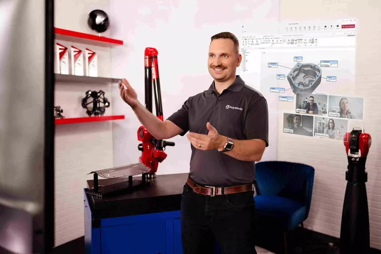 Zwei Messtechniker prüfen ein Bauteil in der Software PolyWorks|Inspector am Bildschirm.
